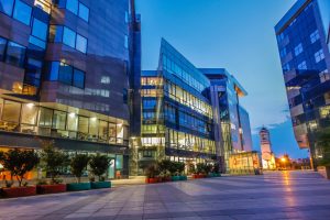 Illuminated modern buildings with glass facades at dusk in Maršić, Serbia.