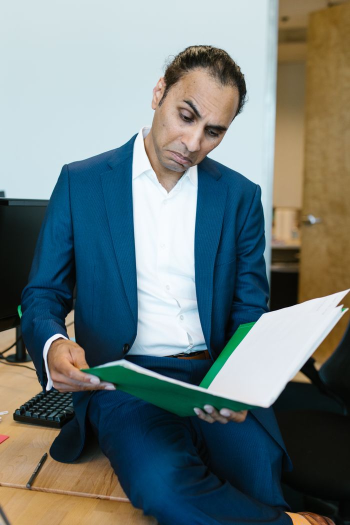 Confident businessman in suit reviewing important documents at his office desk.