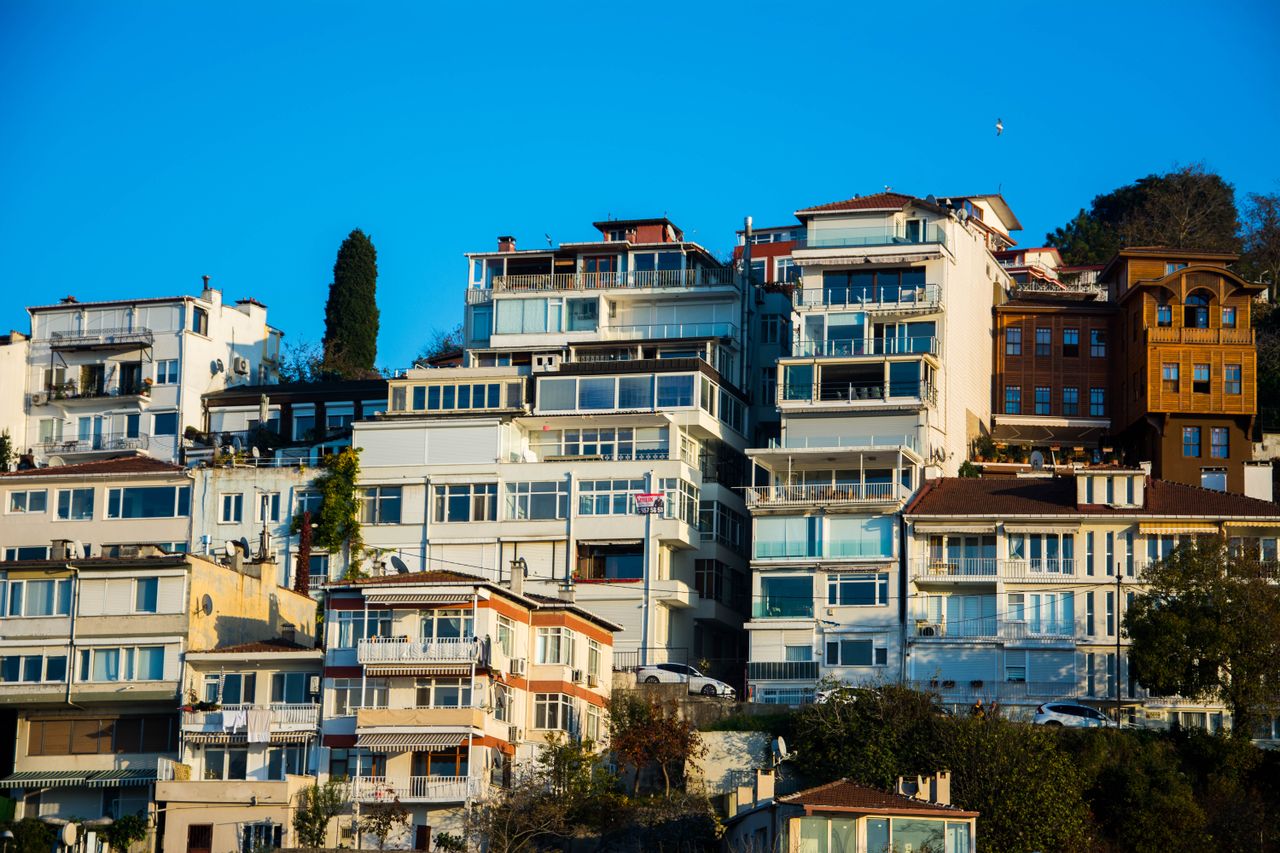Captivating view of hillside residential buildings under a vibrant blue sky, showcasing modern architectural design.